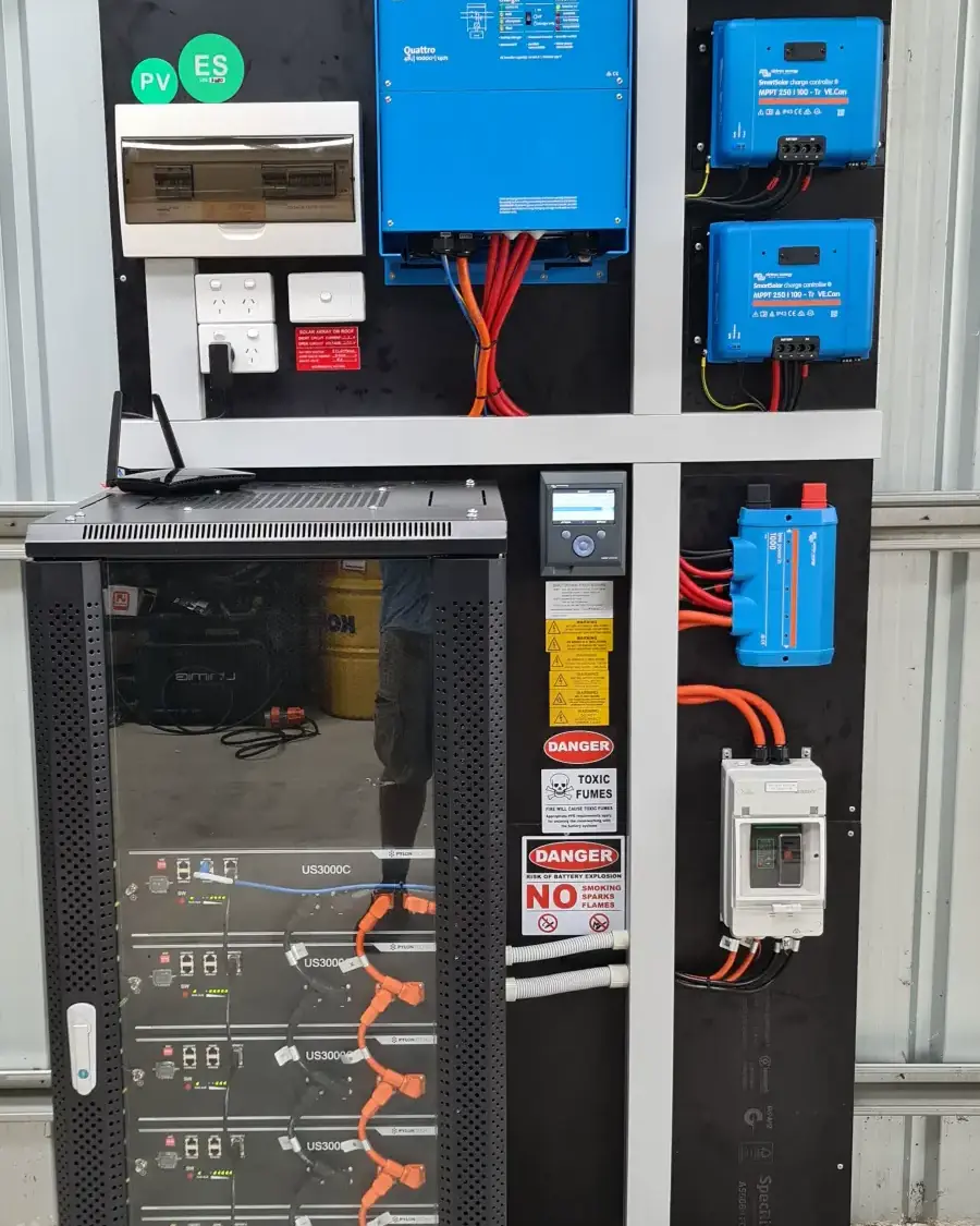 An off-grid battery cabinet with inverter and charge controllers mounted on a wall