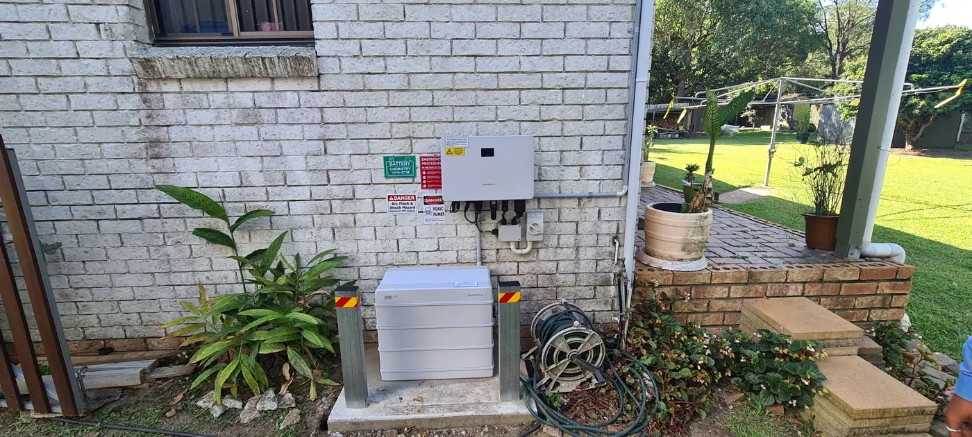 A home battery and inverter installed outside a brick house