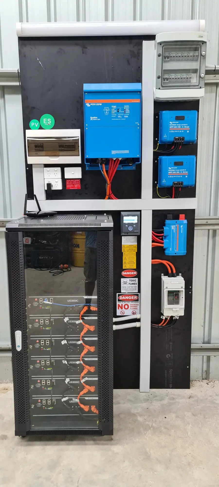 An off-grid power cabinet with Victron controllers and a rack of lithium batteries
