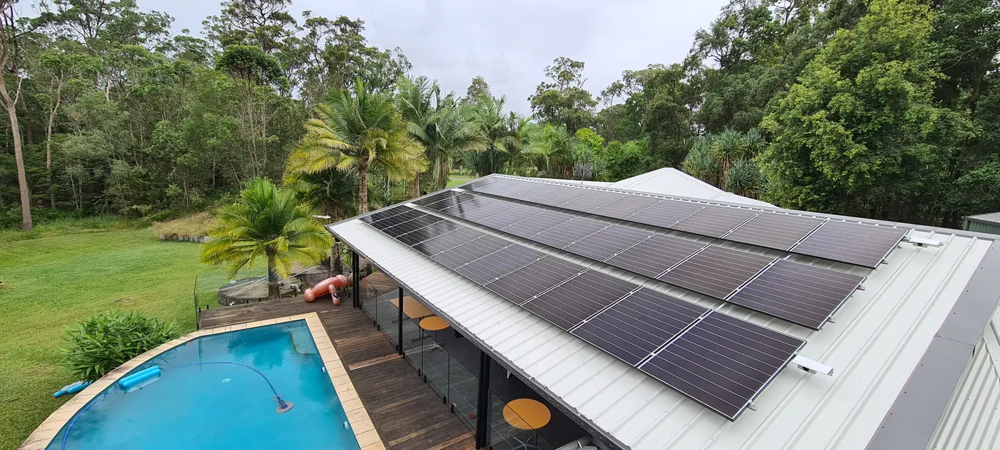 Solar panels on a roof above a backyard pool